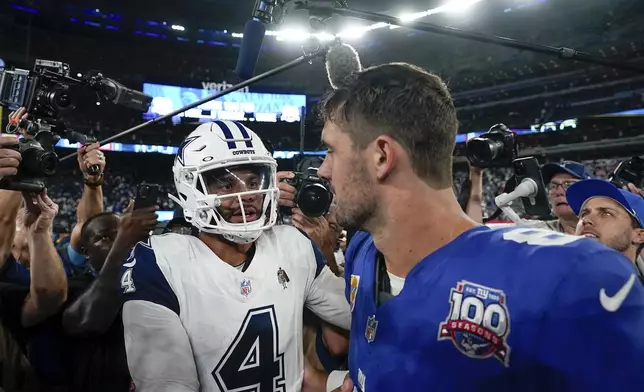 Dallas Cowboys quarterback Dak Prescott (4) talks with New York Giants quarterback Daniel Jones (8) on the field after playing in an NFL football game, Thursday, Sept. 26, 2024, in East Rutherford, N.J. (AP Photo/Bryan Woolston)