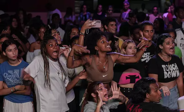 Youths react as they watch dancers participate in a K-pop contest at a cultural house in Havana, Cuba, Saturday, Sept. 7, 2024. (AP Photo/Ramon Espinosa)