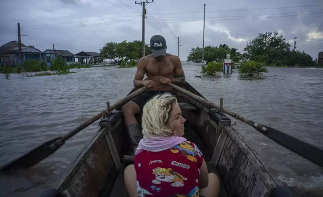 People traverse a flooded street on a boat after the passage of Hurricane Helene in Guanimar, Artemisa province, Cuba, Wednesday, Sept. 25, 2024. (AP Photo/Ramon Espinosa)