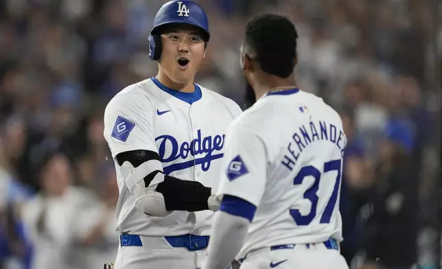 Los Angeles Dodgers designated hitter Shohei Ohtani (17) celebrates with Teoscar Hernández (37) after hitting a home run during the first inning of a baseball game against the Chicago Cubs in Los Angeles, Wednesday, Sept. 11, 2024. (AP Photo/Ashley Landis)