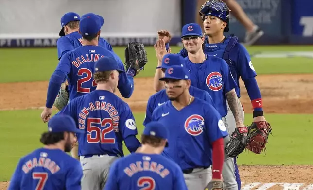 Members of the Chicago Cubs congratulate each other after the Cubs defeated the Los Angeles Dodgers 10-4 in a baseball game, Monday, Sept. 9, 2024, in Los Angeles. (AP Photo/Mark J. Terrill)