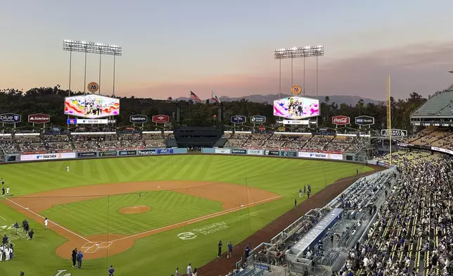 Smoke from wildfires can be seen behind Dodger Stadium prior to a baseball game between the Los Angeles Dodgers and the Chicago Cubs, Monday, Sept. 9, 2024, in Los Angeles. (AP Photo/Beth Harris)