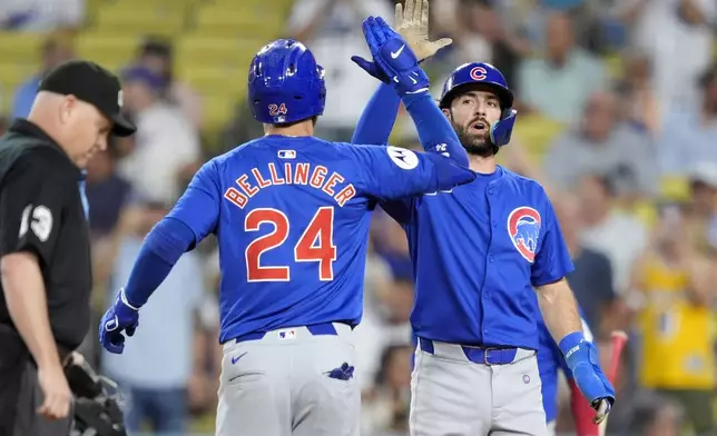 Chicago Cubs' Cody Ballinger, left, is congratulated by Dansby Swanson after hitting a two-run home run during the first inning of a baseball game against the Los Angeles Dodgers, Monday, Sept. 9, 2024, in Los Angeles. (AP Photo/Mark J. Terrill)