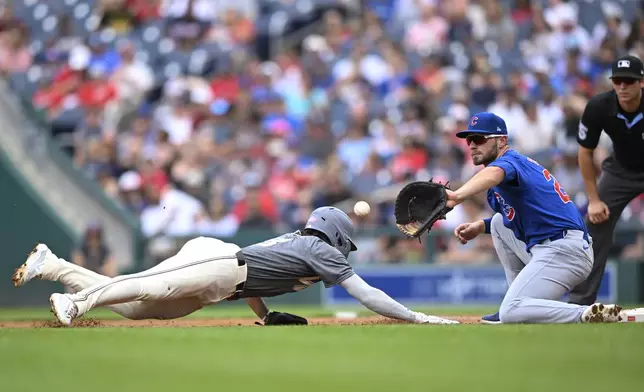 Washington Nationals' Jose Tena, left, is safe as he beats the pickoff throw to Chicago Cubs first baseman Michael Busch during the second inning of a baseball game Saturday, Aug. 31, 2024, in Washington. (AP Photo/John McDonnell)