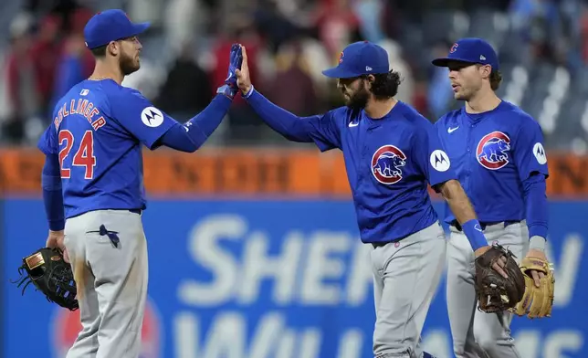 Chicago Cubs' Cody Bellinger, from left, Dansby Swanson and Nico Hoerner celebrate after the Cubs won a baseball game against the Philadelphia Phillies, Tuesday, Sept. 24, 2024, in Philadelphia. (AP Photo/Matt Slocum)