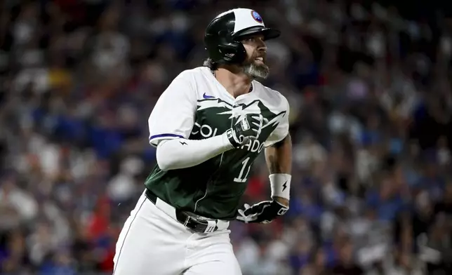 Colorado Rockies' Jake Cave runs to second base on a double in the seventh inning of a baseball game against the Chicago Cubs, Saturday, Sept. 14, 2024, in Denver. (AP Photo/Geneva Heffernan)