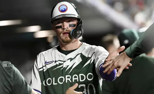 Colorado Rockies' Aaron Schunk celebrates after scoring in the sixth inning of a baseball game against the Chicago Cubs, Saturday, Sept. 14, 2024, in Denver. (AP Photo/Geneva Heffernan)