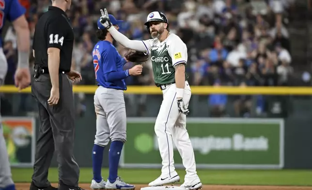 Colorado Rockies' Jake Cave (right) celebrates after hitting a double in the seventh inning of a baseball game against the Chicago Cubs, Saturday, Sept. 14, 2024, in Denver. (AP Photo/Geneva Heffernan)