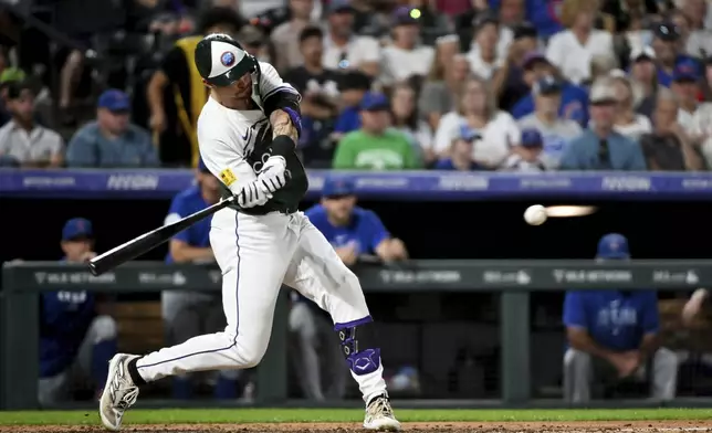 Colorado Rockies' Brenton Doyle hits an RBI sacrifice fly ball in the sixth inning of a baseball game against the Chicago Cubs, Saturday, Sept. 14, 2024, in Denver. (AP Photo/Geneva Heffernan)