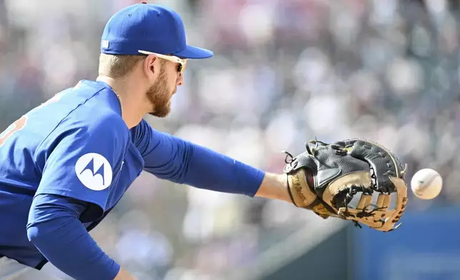 Chicago Cubs first baseman Michael Busch catches a baseball for an out at first base in the eighth inning of a baseball game against the Colorado Rockies, Sunday, Sept. 15, 2024, in Denver. (AP Photo/Geneva Heffernan)