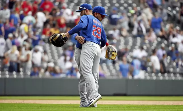 Chicago Cubs first baseman Michael Busch (29) and third baseman Isaac Paredes, back, celebrate after a baseball game against the Colorado Rockies, Sunday, Sept. 15, 2024, in Denver. (AP Photo/Geneva Heffernan)