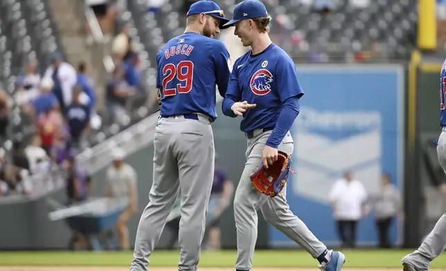 Chicago Cubs first baseman Michael Busch (29) and center fielder Pete Crow-Armstrong, right, celebrate after a baseball game against the Colorado Rockies, Sunday, Sept. 15, 2024, in Denver. (AP Photo/Geneva Heffernan)