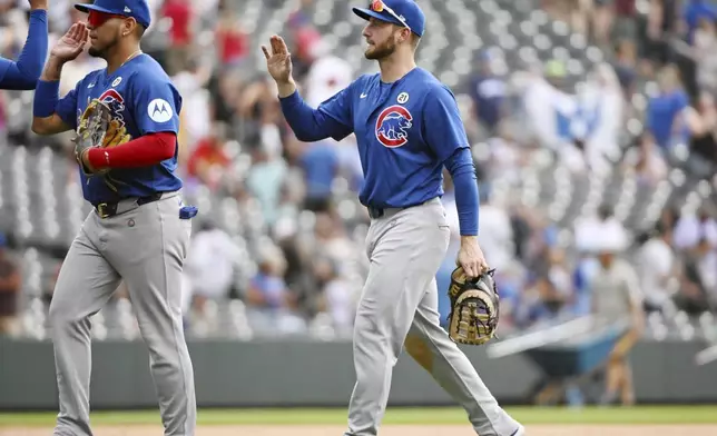 Chicago Cubs third baseman Isaac Paredes, left, and first baseman Michael Busch, right, celebrate after a baseball game against the Colorado Rockies, Sunday, Sept. 15, 2024, in Denver. (AP Photo/Geneva Heffernan)