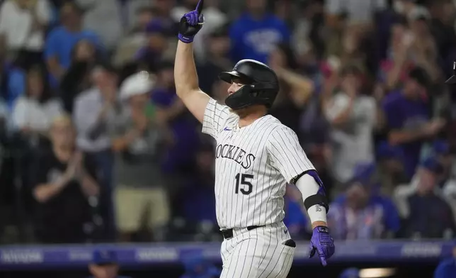 Colorado Rockies' Hunter Goodman gestures as he crosses home plate after hitting a grand slam off Chicago Cubs relief pitcher Nate Pearson in the eighth inning of a baseball game, Friday, Sept. 13, 2024, in Denver. (AP Photo/David Zalubowski)