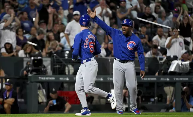 Chicago Cubs' Pete Crow-Armstrong, left, celebrates with third base coach Willie Harris while running the bases after hitting a home run in the seventh inning of a baseball game against the Colorado Rockies, Saturday, Sept. 14, 2024, in Denver. (AP Photo/Geneva Heffernan)