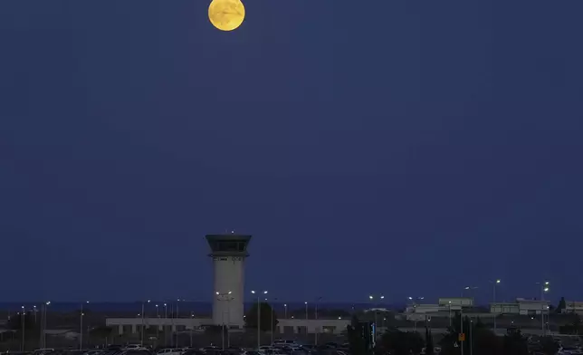 A Supermoon rises over the control tower of Larnaca international airport in the eastern Mediterranean island of Cyprus, on Tuesday, Sept. 17, 2024. (AP Photo/Petros Karadjias)