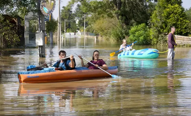 Residents paddle through a flooded street in Bohumin, Czech Republic, Tuesday, Sept. 17, 2024. (AP Photo/Darko Bandic)