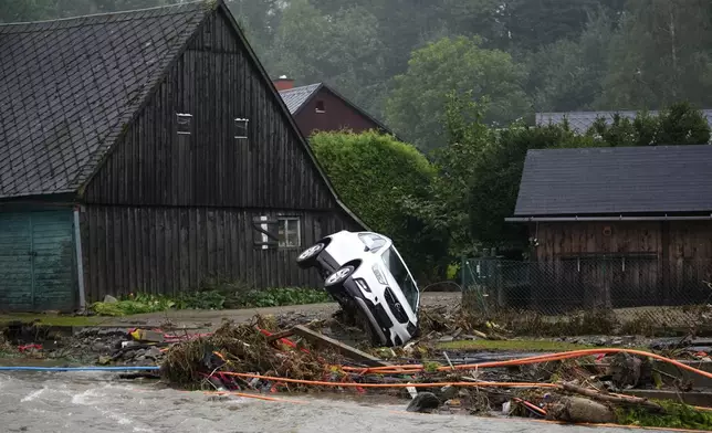 A car is stucked on a river bank after recent floods in Domasov, Czech Republic, Monday, Sept. 16, 2024. (AP Photo/Petr David Josek)