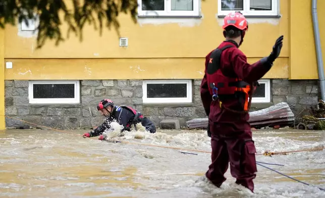 A rescue worker struggles against a strong current during an evacuation operation during floods in Jesenik, Czech Republic, Sunday, Sept. 15, 2024. (AP Photo/Petr David Josek)