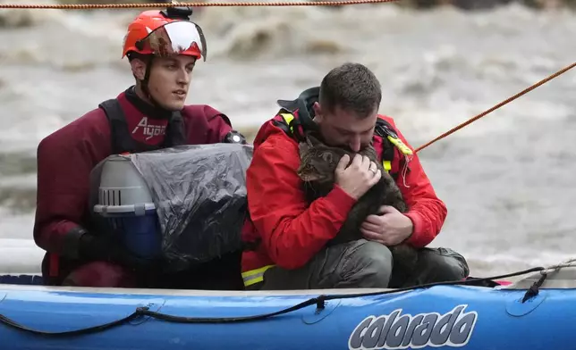 A resident with his cat is taken by a rubber boat from his flooded house in Jesenik, Czech Republic, Sunday, Sept. 15, 2024. (AP Photo/Petr David Josek)