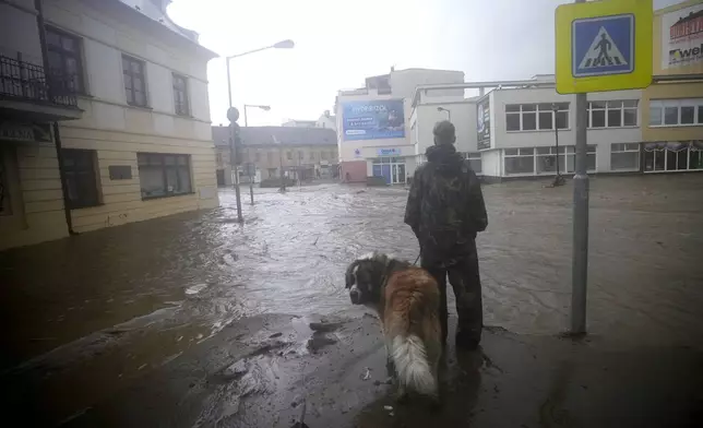 A resident looks at the flooded streets of Jesenik, Czech Republic, Sunday, Sept. 15, 2024. (AP Photo/Petr David Josek)