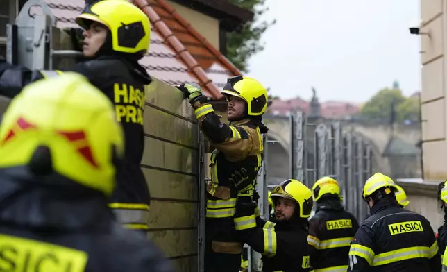 Firefighters adjust parts of the anti-flood barriers in Prague, Czech Republic, Friday, Sept. 13, 2024. (AP Photo/Petr David Josek)