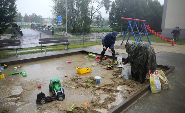 Residents fill sand bags to protect their houses during floods in Jesenik, Czech Republic, Sunday, Sept. 15, 2024. (AP Photo/Petr David Josek)