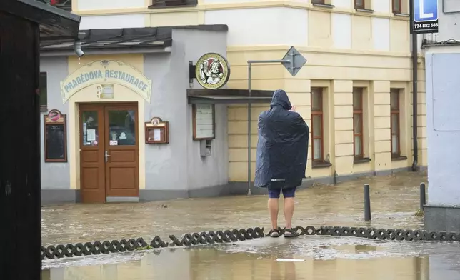 A resident looks at the flooded city center of Jesenik, Czech Republic, Sunday, Sept. 15, 2024. (AP Photo/Petr David Josek)