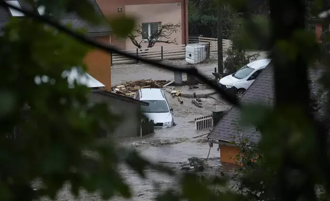 Cars submerge in flood water in Jesenik, Czech Republic, Sunday, Sept. 15, 2024. (AP Photo/Petr David Josek)