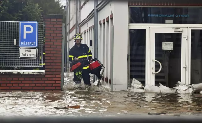 A firefighter wades through flooded streets in Opava, Czech Republic, Sunday Sept. 15, 2024. (Jaroslav Ozana/CTK via AP)