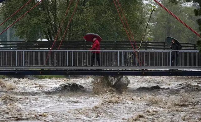 Residents cross a bridge during floods in Jesenik, Czech Republic, Sunday, Sept. 15, 2024. (AP Photo/Petr David Josek)