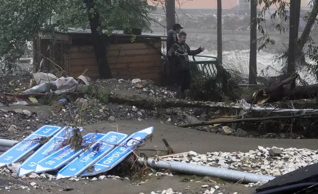 Residents look at the damage done by recent floods in Jesenik, Czech Republic, Monday, Sept. 16, 2024. (AP Photo/Petr David Josek)