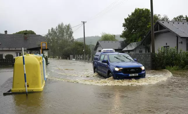 A car drives through a flooded street in Brantice, Czech Republic, Saturday, Sept. 14, 2024. (AP Photo/Petr David Josek)