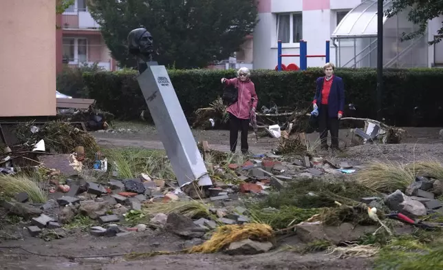 Residents look at the damage done by recent floods in Jesenik, Czech Republic, Monday, Sept. 16, 2024. (AP Photo/Petr David Josek)