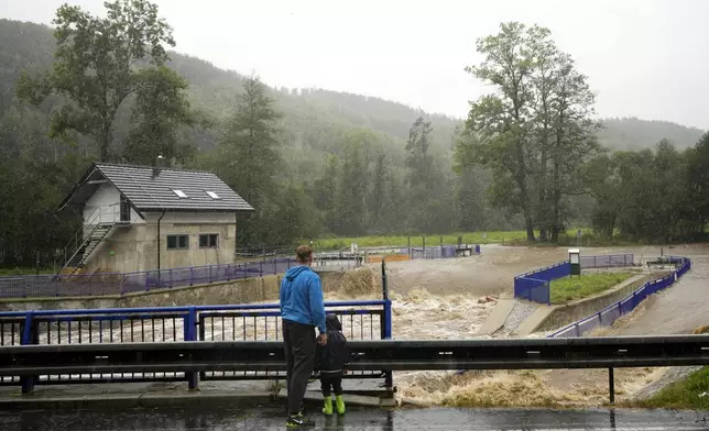 Residents watch the rising levels of the Opava river near Brantice, Czech Republic, Saturday, Sept. 14, 2024. (AP Photo/Petr David Josek)