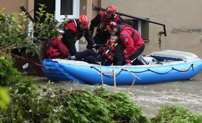 A resident is evacuated from his flooded house in Jesenik, Czech Republic, Sunday, Sept. 15, 2024. (AP Photo/Petr David Josek)