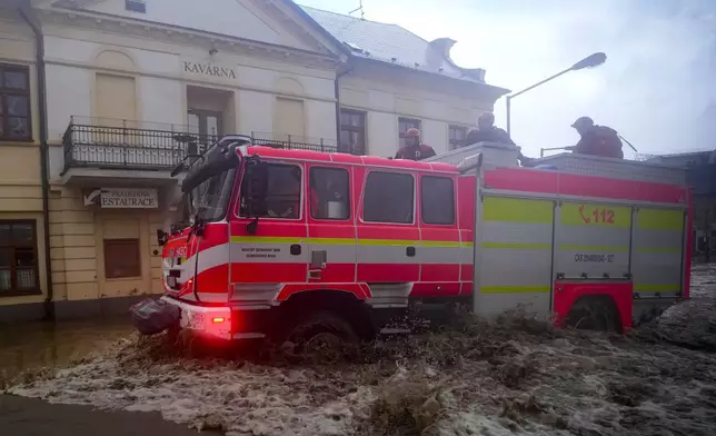 Firemen drive through flooded streets of Jesenik, Czech Republic, Sunday, Sept. 15, 2024. (AP Photo/Petr David Josek)