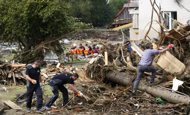 Residents clean up after recent floods in Mikulovice, Czech Republic, Thursday, Sept. 19, 2024. (AP Photo/Petr David Josek)