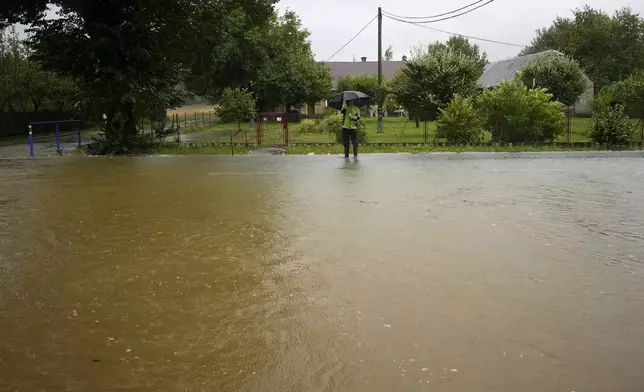 A resident takes a photo of a flooded street in Brantice, Czech Republic, Saturday, Sept. 14, 2024. (AP Photo/Petr David Josek)