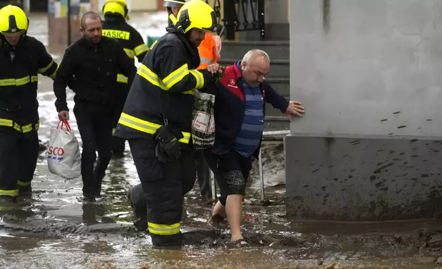 Firemen help residents during floods in Jesenik, Czech Republic, Sunday, Sept. 15, 2024. (AP Photo/Petr David Josek)