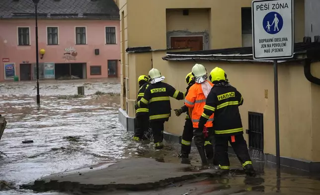 Firemen attend to a house during floods in Jesenik, Czech Republic, Sunday, Sept. 15, 2024. (AP Photo/Petr David Josek)