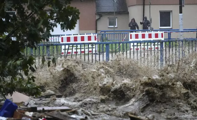 Residents watch the river during floods Jesenik, Czech Republic, Sunday, Sept. 15, 2024. (AP Photo/Petr David Josek)