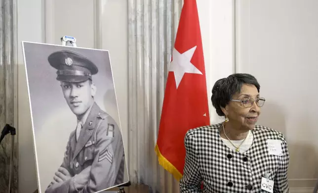 Joann Woodson stands near a portrait of her husband U.S. Army Staff Sgt. Waverly Woodson Jr., prior to a ceremony to posthumously award the Distinguished Service Cross to him, a medic who was part of the only Black combat unit to take part in the D-Day invasion of France during World War II, on Capitol Hill, in Washington, Tuesday, Sept. 24, 2024. (AP Photo/Rod Lamkey, Jr.)