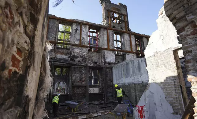 Workers clear rubble at Copenhagen's Old Stock Exchange building in Copenhagen, Denmark, Thursday, Sept. 19, 2024. (AP Photo James Brooks)