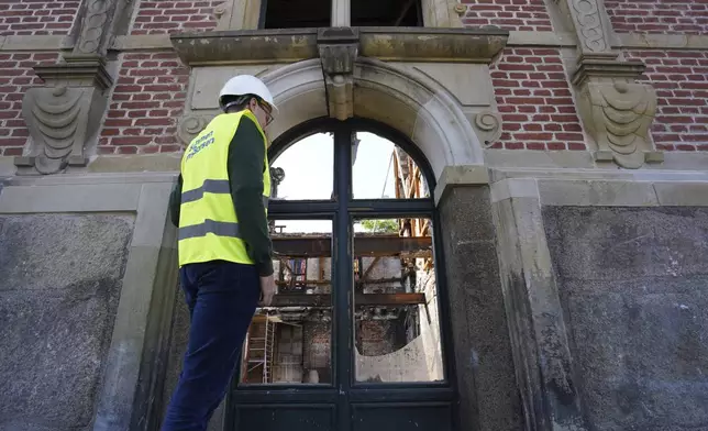 Lars Daugaard Jepsen, head of reconstruction at Denmark's Chamber of Commerce, peers through a window at Copenhagen's Old Stock Exchange building in Copenhagen, Denmark, Thursday, Sept. 19, 2024. (AP Photo James Brooks)