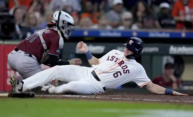 Houston Astros' Jake Meyers (6) slides past Arizona Diamondbacks catcher Jose Herrera to score on Chas McCormick's 2-run single during the fourth inning of a baseball game, Saturday, Sept. 7, 2024, in Houston. (AP Photo/Eric Christian Smith)