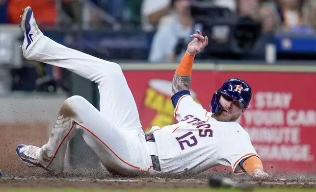 Houston Astros' Ben Gamel slides to score on Yordan Alvarez's RBI single against the Arizona Diamondbacks during the fourth inning of a baseball game Saturday, Sept. 7, 2024, in Houston. (AP Photo/Eric Christian Smith)