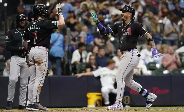 Arizona Diamondbacks' Ketel Marte is congratulated by Corbin Carroll (7) after hitting a two-run home run during the ninth inning of a baseball game against the Milwaukee Brewers, Saturday, Sept. 21, 2024, in Milwaukee. (AP Photo/Aaron Gash)