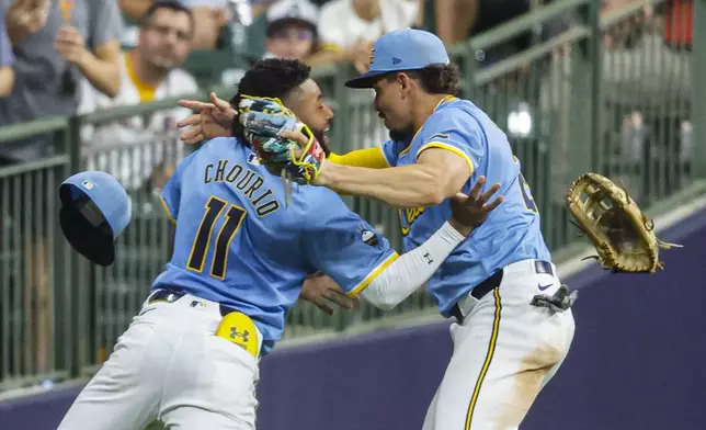 Milwaukee Brewers' Jackson Chourio, left, and Willy Adames, right, collide after Adames caught a ball hit by Arizona Diamondbacks' Jake McCarthy during the eighth inning of a baseball game Friday, Sept. 20, 2024, in Milwaukee. (AP Photo/Jeffrey Phelps)