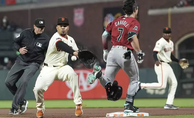 Arizona Diamondbacks' Corbin Carroll (7) is safe at first base on an RBI single as San Francisco Giants first baseman LaMonte Wade Jr., second from left, reaches for the ball during the eighth inning of a baseball game in San Francisco, Wednesday, Sept. 4, 2024. (AP Photo/Jeff Chiu)